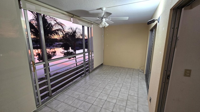 balcony at dusk featuring ceiling fan