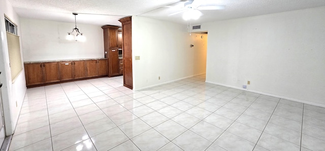 empty room with ceiling fan with notable chandelier and a textured ceiling