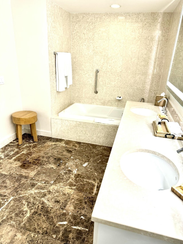 bathroom featuring vanity and tiled tub