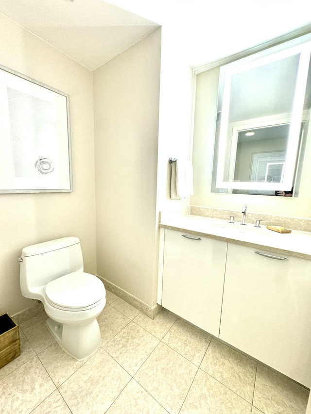 bathroom with tile patterned flooring, vanity, and toilet