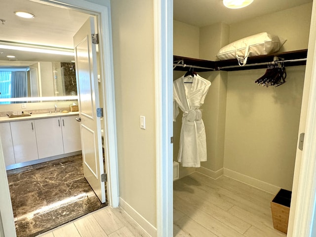 spacious closet featuring light hardwood / wood-style floors and sink