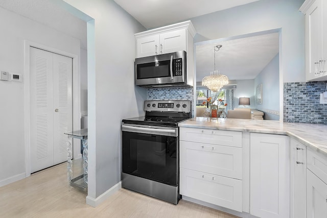 kitchen featuring light hardwood / wood-style floors, white cabinetry, appliances with stainless steel finishes, and tasteful backsplash