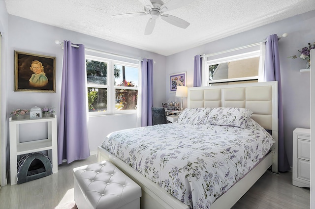 bedroom featuring ceiling fan, a textured ceiling, and hardwood / wood-style flooring