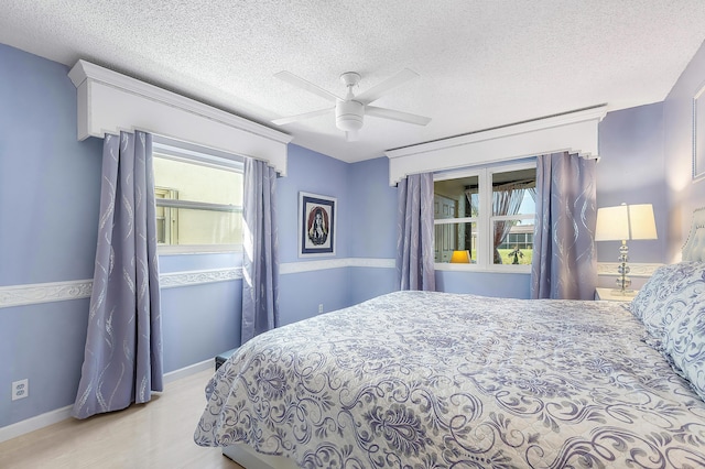 bedroom with light wood-type flooring, a textured ceiling, and ceiling fan