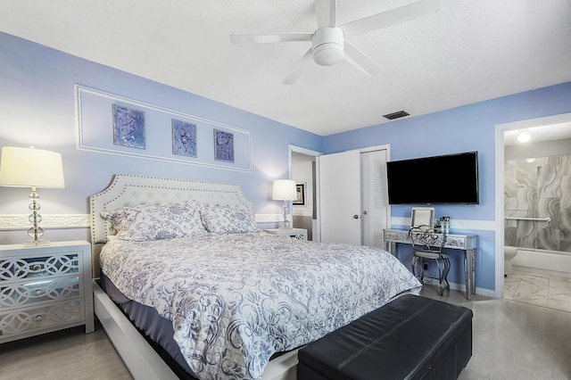 bedroom with hardwood / wood-style flooring, ceiling fan, connected bathroom, and a closet