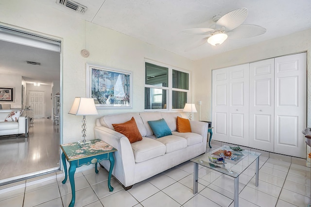 living room with ceiling fan and light tile patterned floors