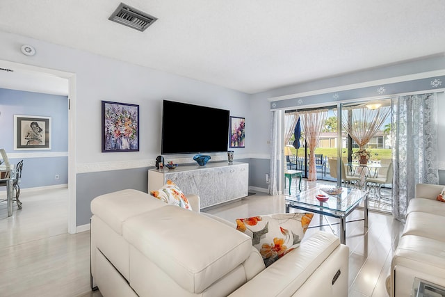 living room featuring light hardwood / wood-style floors and a textured ceiling