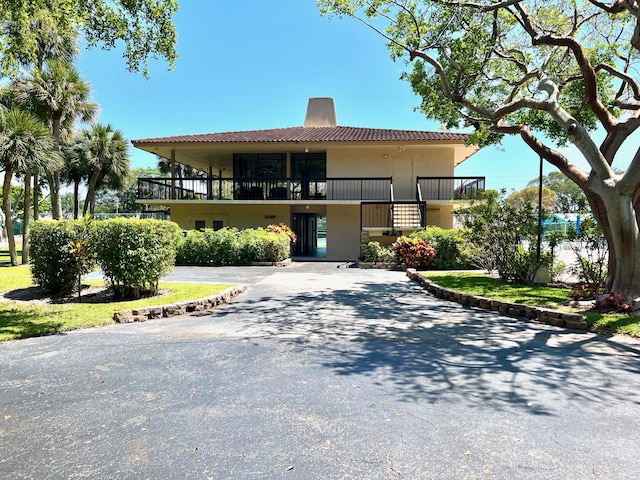 5280 NW 2nd Ave Unit 314, Boca Raton, FL 33487 - view of front of house with stucco siding, a chimney, driveway, a balcony, and a tiled roof