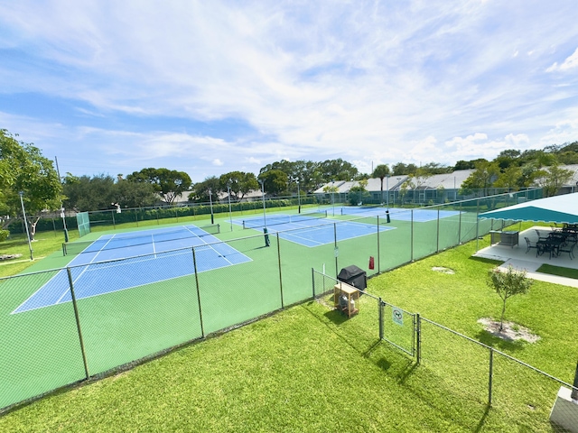 view of sport court with a lawn