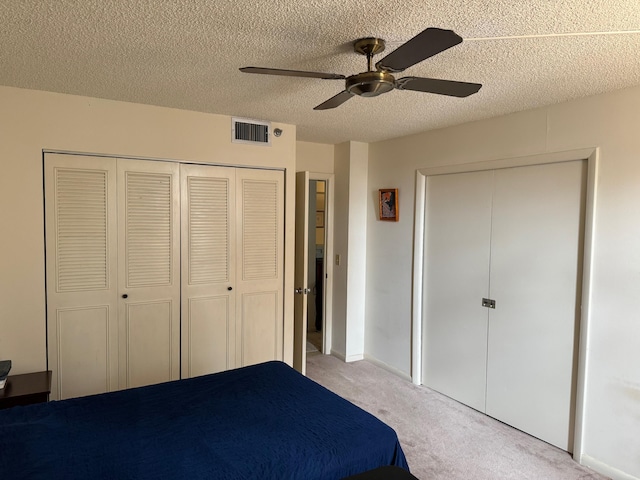 unfurnished bedroom featuring a textured ceiling, light colored carpet, and ceiling fan