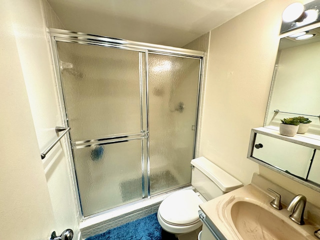 bathroom featuring vanity, toilet, and an enclosed shower