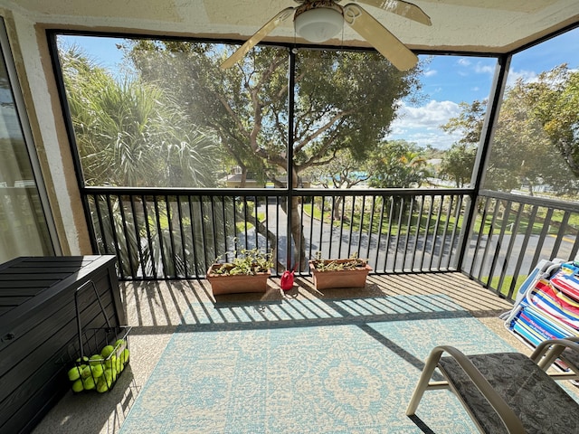 unfurnished sunroom with ceiling fan