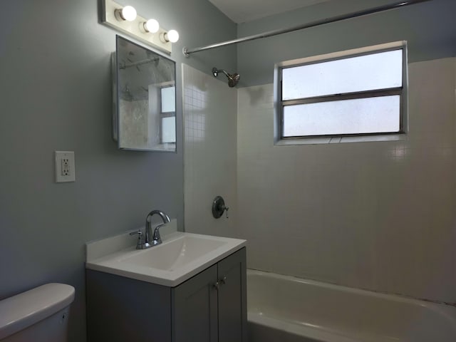 full bathroom with vanity, tiled shower / bath combo, and toilet