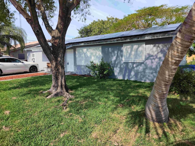 view of home's exterior with a lawn and solar panels