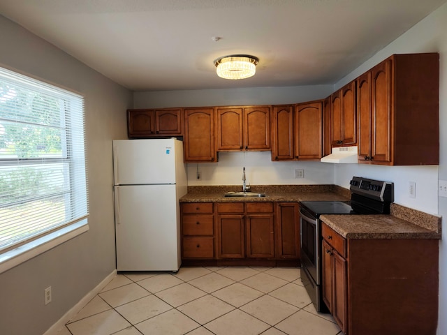 kitchen featuring stainless steel electric range oven, white fridge, sink, and light tile patterned flooring