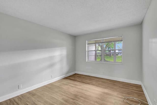 empty room featuring light hardwood / wood-style floors and a textured ceiling