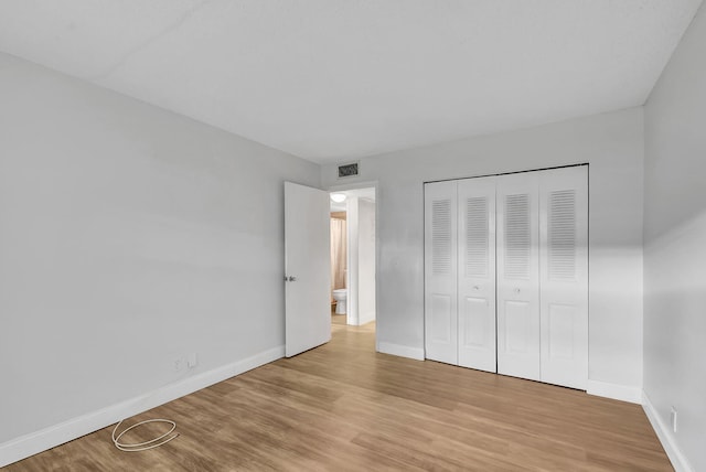 unfurnished bedroom featuring light wood-type flooring and a closet