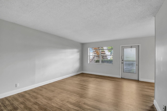 unfurnished room featuring wood-type flooring and a textured ceiling