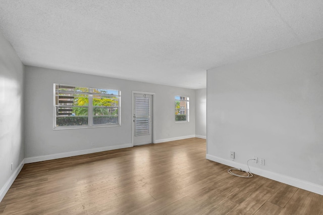 unfurnished room featuring hardwood / wood-style floors and a textured ceiling