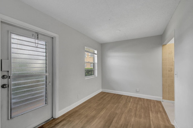 entryway with a textured ceiling and light hardwood / wood-style flooring