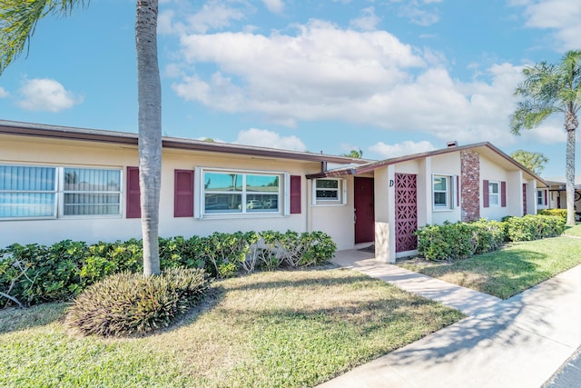 single story home featuring a front lawn