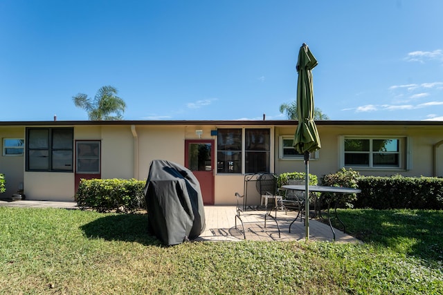 back of house with a patio area and a lawn