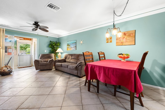 tiled dining space with ceiling fan with notable chandelier and crown molding