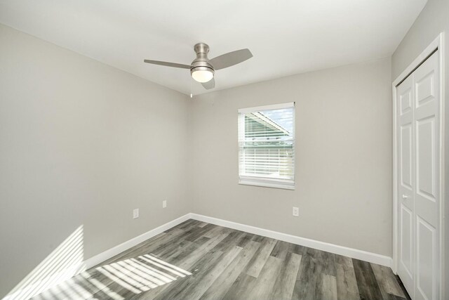 unfurnished bedroom featuring ceiling fan, a closet, and hardwood / wood-style flooring