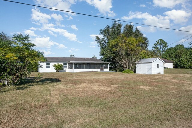 view of yard with a sunroom and a storage shed