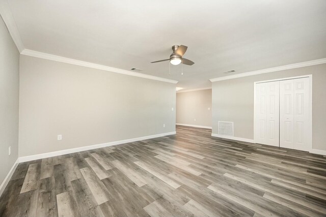 spare room featuring wood-type flooring, ceiling fan, and crown molding