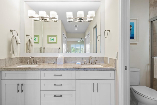 bathroom with vanity, an inviting chandelier, and toilet