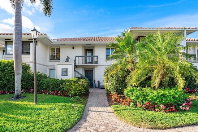 view of front of property with a balcony and a front yard