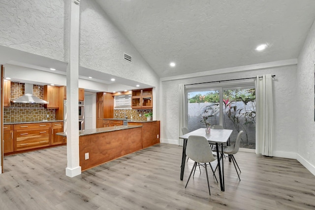 dining space with lofted ceiling, light hardwood / wood-style flooring, and sink