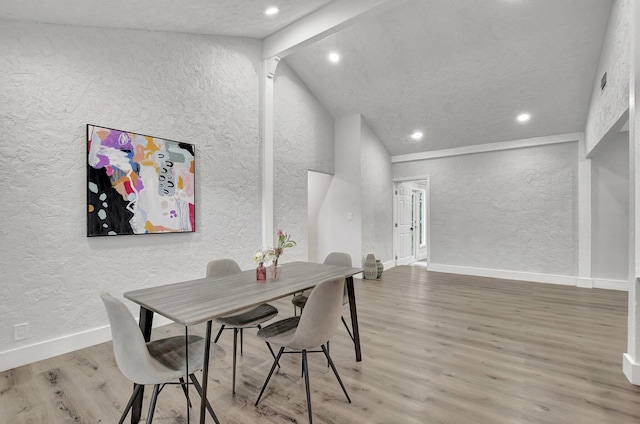 dining area featuring high vaulted ceiling, hardwood / wood-style floors, and beam ceiling