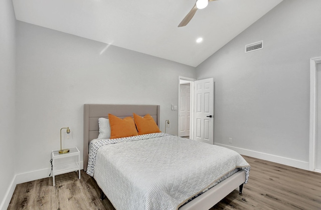 bedroom with ceiling fan, vaulted ceiling, and hardwood / wood-style flooring