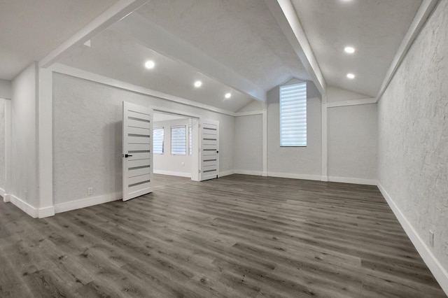 basement featuring a textured wall, recessed lighting, dark wood finished floors, and baseboards