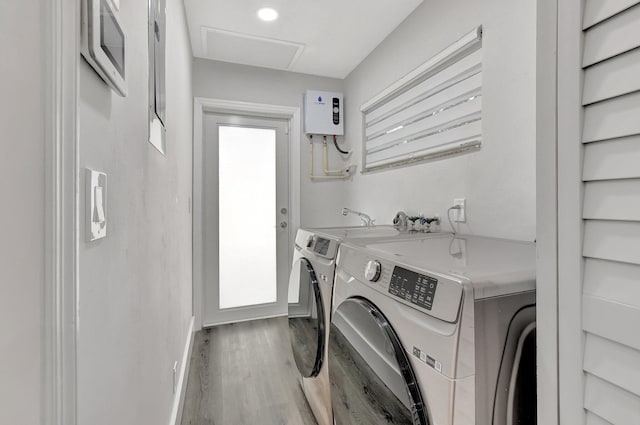 laundry room featuring light hardwood / wood-style flooring, washer and clothes dryer, and water heater