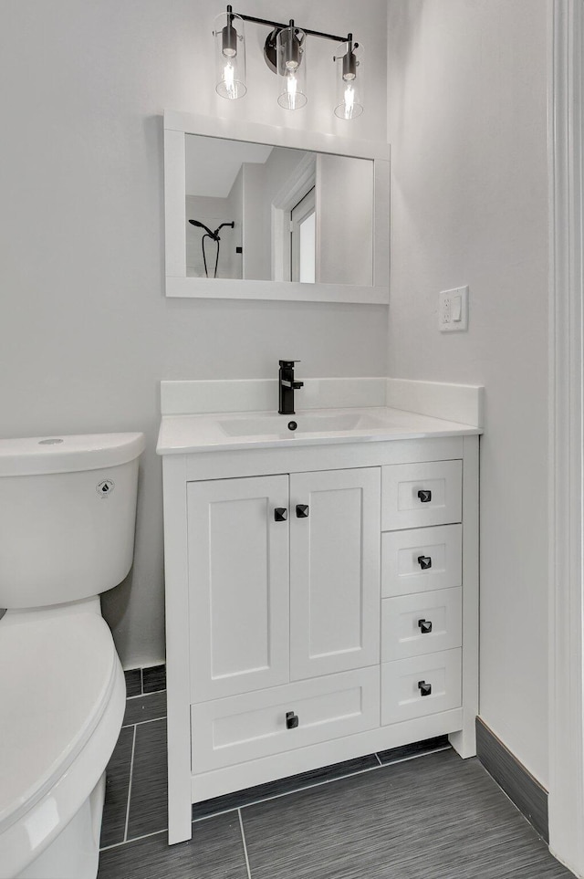 bathroom featuring tile patterned flooring, vanity, and toilet