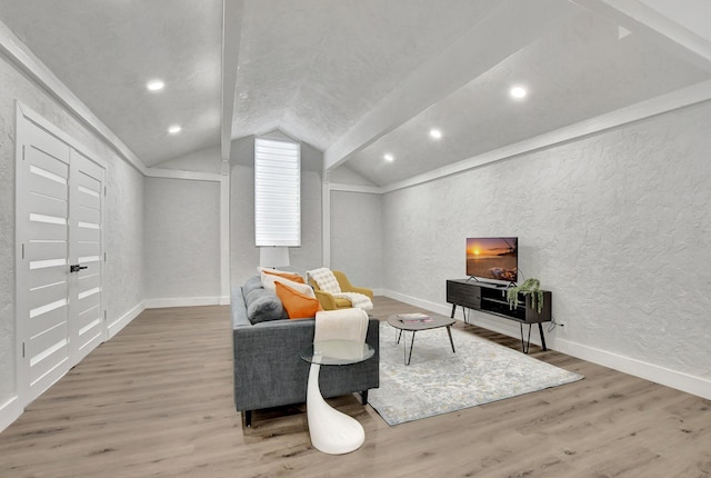 living room with lofted ceiling with beams, hardwood / wood-style flooring, and ornamental molding