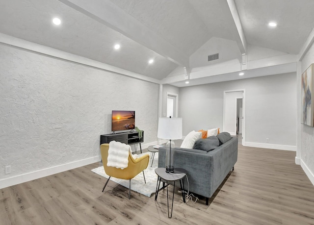 living room with vaulted ceiling with beams and hardwood / wood-style flooring