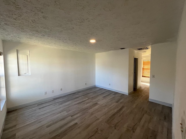 empty room with a textured ceiling and hardwood / wood-style flooring