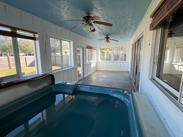 unfurnished sunroom featuring a jacuzzi and ceiling fan