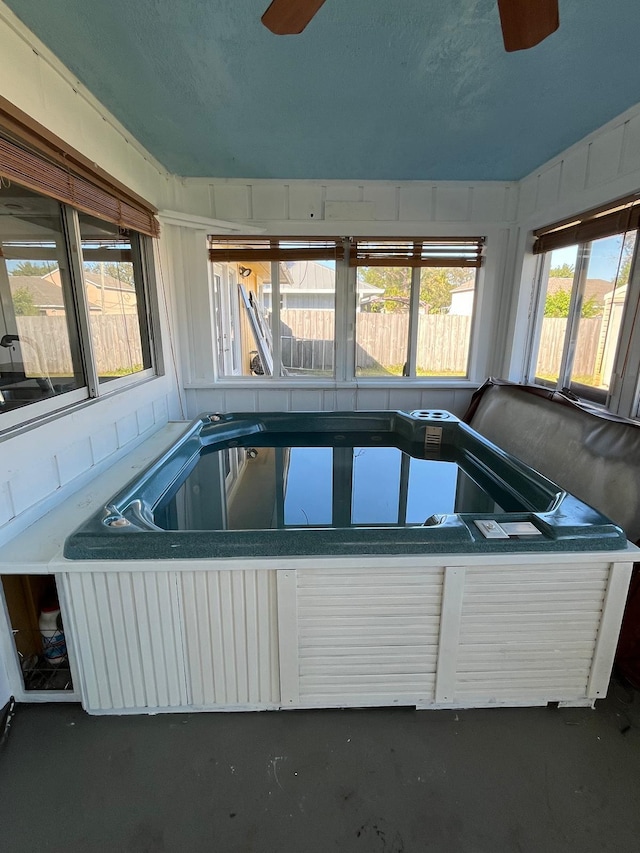 interior space with ceiling fan and an indoor hot tub