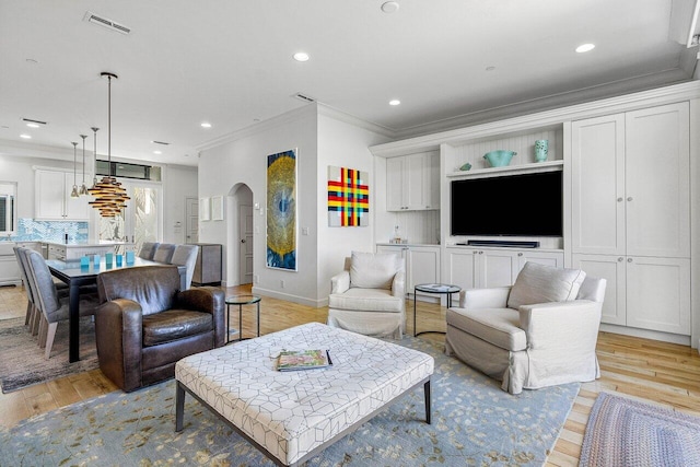 living room featuring crown molding and light wood-type flooring