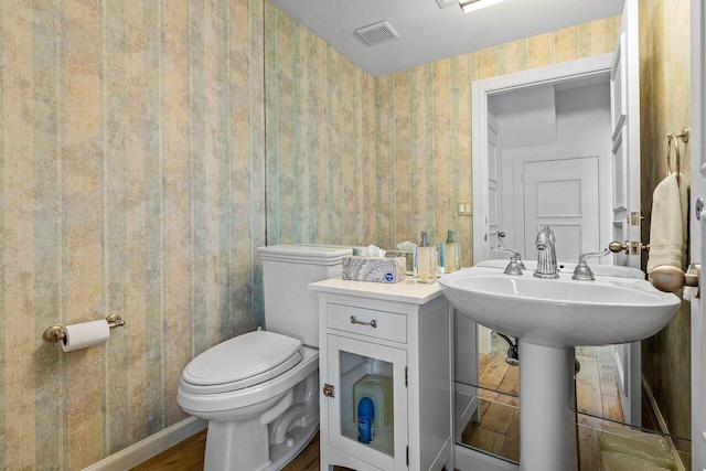 bathroom featuring hardwood / wood-style flooring and toilet