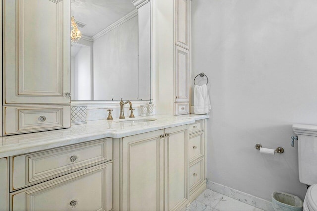 bathroom with vanity, toilet, and ornamental molding