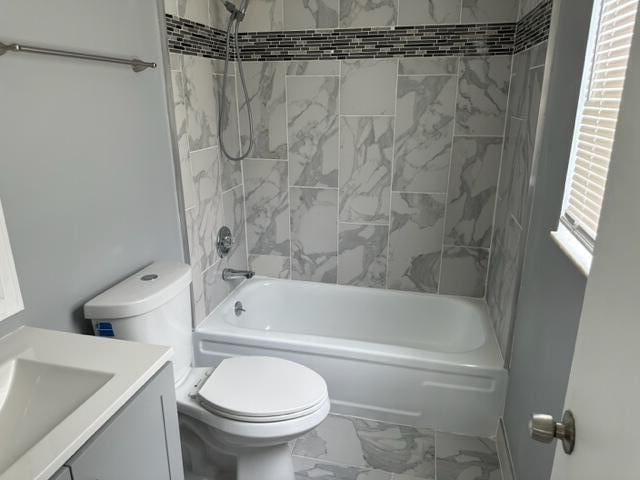 full bathroom featuring vanity, toilet, and tiled shower / bath