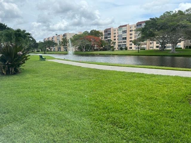 view of community with a lawn and a water view