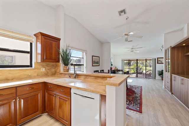 kitchen with white dishwasher, sink, light hardwood / wood-style flooring, ceiling fan, and butcher block counters