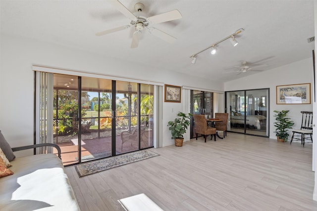 unfurnished living room featuring ceiling fan, vaulted ceiling, and light wood-type flooring